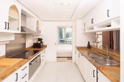 a kitchen with white cabinets and a sink at Elite Royal Apartment - Full Burj Khalifa & New Fountain View - Panoramic - Luxurious - Magnus in Dubai