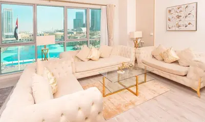 a living room with white furniture and a large window at Elite Royal Apartment - Full Burj Khalifa & New Fountain View - Panoramic - Luxurious - Magnus in Dubai