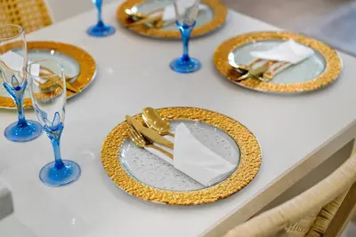 a table with plates and glasses on a table at Beachfront Studio JBR - Murjan 2 by Home Of Choice in Dubai