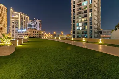 a large field of grass in a city at night at Lux Stay In Dubai Marina BCOM in Dubai