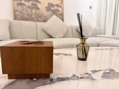 a living room with a couch and a table with a vase at 2 BR with Full Burj View 10 min Walk to Dubai Mall in Dubai