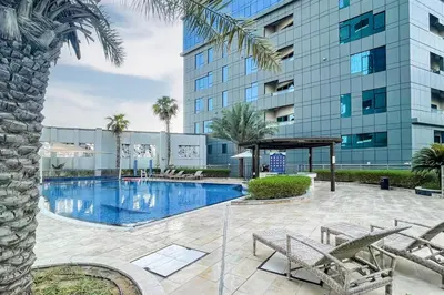a swimming pool in front of a building at C&L Homes with Burj Khalifa view in Dubai