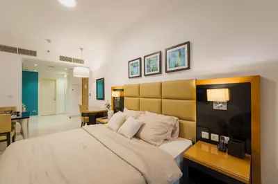 a bedroom with a large bed with a desk and a room at C&L Homes with Burj Khalifa view in Dubai