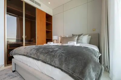 a bedroom with a large bed and a large window at Ultra Luxury 2BD Beachfront & Panoramic Sea Views in Dubai