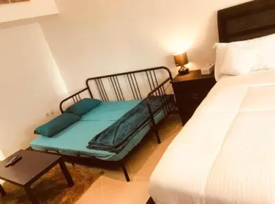 a room with a chair next to a bed and a table at Royal Marina Inn in Dubai