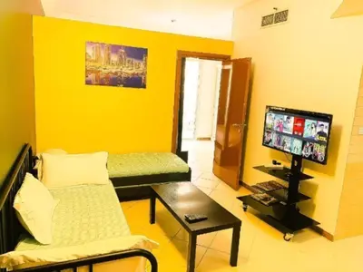 a living room with a couch and a flat screen tv at Royal Marina Inn in Dubai