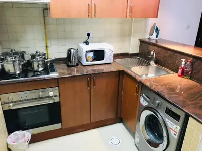 a small kitchen with a microwave and a sink at Royal Marina Inn in Dubai