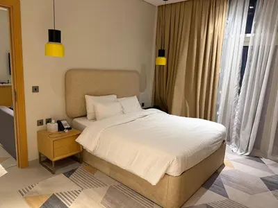 a bedroom with a bed and a table with a night stand at A luxurious 1 bedroom and living room in Dubai