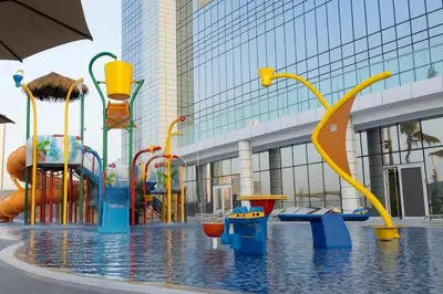 a water park with a water slide in front of a building at A luxurious 1 bedroom and living room in Dubai