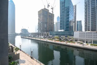 a river in the middle of a city with tall buildings at Waterfront Luxe Haven Peninsula in Dubai