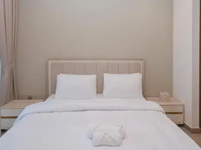a white bed with a white towel on it at Waterfront Luxe Haven Peninsula in Dubai