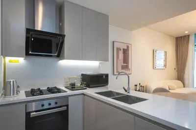 a kitchen with a sink and a stove top oven at Waterfront Luxe Haven Peninsula in Dubai