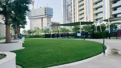 a park with a green lawn in a city at Stunning 2 Bedroom Aykon City Tower C in Dubai