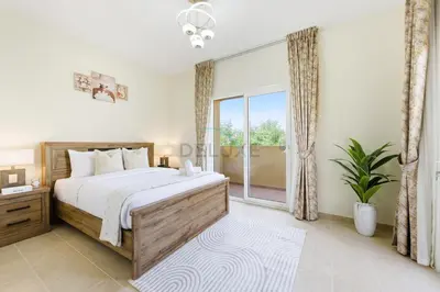 a bedroom with a bed and a large window at Serene 2BR Villa, Minutes Drive to Miracle Garden and Dubai Butterfly Garden, Steps from Golf Course, Palmera 2, Arabian Ranches by Deluxe Holiday Homes in Dubai