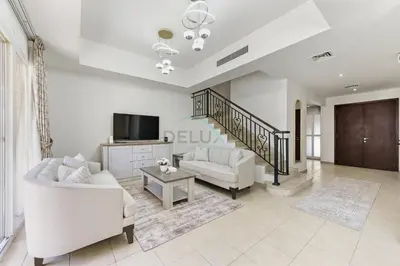 a living room with white furniture and a staircase at Serene 2BR Villa, Minutes Drive to Miracle Garden and Dubai Butterfly Garden, Steps from Golf Course, Palmera 2, Arabian Ranches by Deluxe Holiday Homes in Dubai