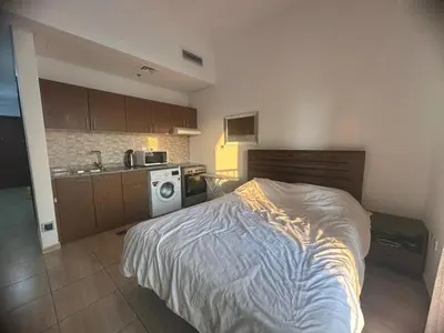a small bedroom with a bed and a kitchen at Burj Sabah in Dubai