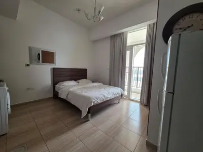 a bedroom with a bed and a clock on the wall at Burj Sabah in Dubai