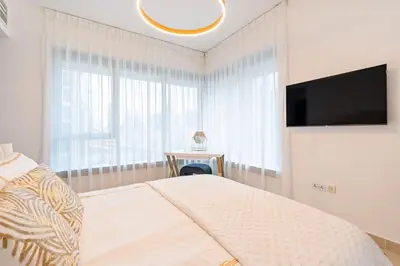 a bedroom with a bed and a flat screen tv at Burj Khalifa District Luxury Apartment - Downtown Dubai in Dubai