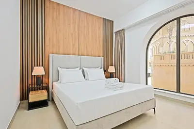 a bedroom with a white bed and a large window at Spacious 4BR in JBR Steps to Beach & Walk in Dubai