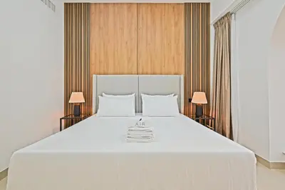 a bedroom with a large white bed with two lamps at Spacious 4BR in JBR Steps to Beach & Walk in Dubai