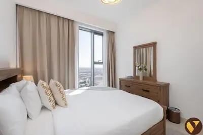 a bedroom with a white bed and a large window at Vogue Creek Harbour Icon Bay Waterfront Living Close to Downtown, Burj Khalifa and Dubai Mall, Three Bedroom Apartment with Large Balcony, Canal and Burj Khalifa View, Access to all Amenities in Dubai