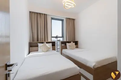 a bedroom with two beds and a window at Vogue Creek Harbour Icon Bay Waterfront Living Close to Downtown, Burj Khalifa and Dubai Mall, Three Bedroom Apartment with Large Balcony, Canal and Burj Khalifa View, Access to all Amenities in Dubai