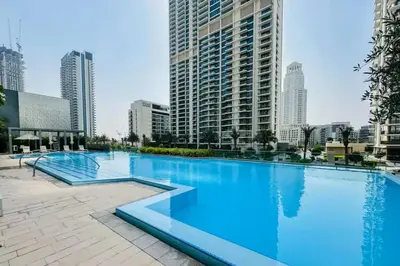 a large swimming pool in a city with tall buildings at Vogue Creek Harbour Icon Bay Waterfront Living Close to Downtown, Burj Khalifa and Dubai Mall, Three Bedroom Apartment with Large Balcony, Canal and Burj Khalifa View, Access to all Amenities in Dubai