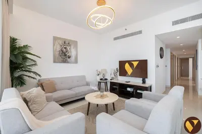 a living room with white furniture and a tv at Vogue Creek Harbour Icon Bay Waterfront Living Close to Downtown, Burj Khalifa and Dubai Mall, Three Bedroom Apartment with Large Balcony, Canal and Burj Khalifa View, Access to all Amenities in Dubai