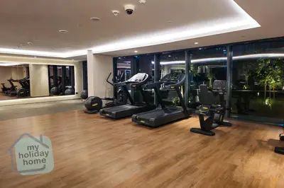 a gym with treadmills and ellipticals in a building at Burj Khalifa View from Roof-Pool & Gym -Parking in Dubai