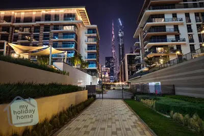 a walkway in a city at night with buildings at Burj Khalifa View from Roof-Pool & Gym -Parking in Dubai