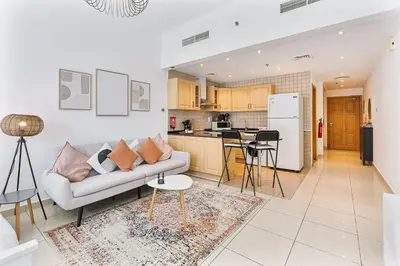 a living room with a couch and a kitchen at Modern Cozy Studio Near Dubai Marina in Dubai
