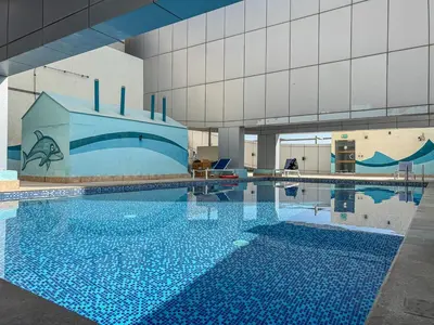 a large swimming pool in a building at Modern Cozy Studio Near Dubai Marina in Dubai