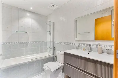 a bathroom with a toilet and a sink and a mirror at Modern Cozy Studio Near Dubai Marina in Dubai
