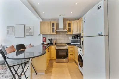 a kitchen with a table and a refrigerator at Modern Cozy Studio Near Dubai Marina in Dubai