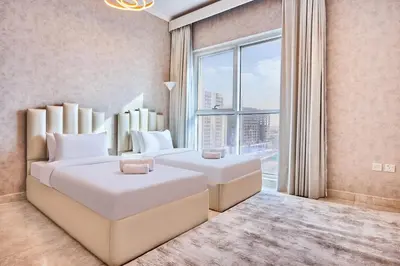 a bedroom with two beds and a large window at 2 Bedroom Apartment Close to Miracle Tower in Dubai