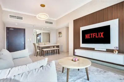 a living room with a television on a wall at 2 Bedroom Apartment Close to Miracle Tower in Dubai