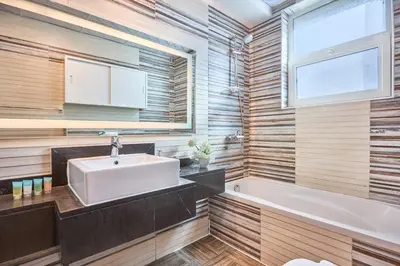 a bathroom with a sink and a tub and a window at 2 Bedroom Apartment Close to Miracle Tower in Dubai