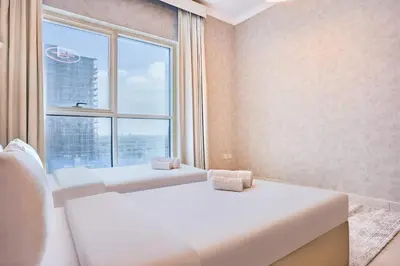 a room with two beds and a large window at 2 Bedroom Apartment Close to Miracle Tower in Dubai