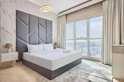 a bedroom with a large white bed and large windows at 2 Bedroom Apartment Close to Miracle Tower in Dubai