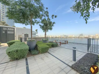 a patio with a bench and trees and bushes at Vogue Creek Harbour Edge Tower Waterfront Living Close to Downtown, Burj Khalifa and Dubai Mall, One Bedroom Apartment with Balcony and Canal View, Access to all Amenities in Dubai