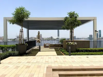 a pavilion with a bench and trees on a building at Vogue Creek Harbour Edge Tower Waterfront Living Close to Downtown, Burj Khalifa and Dubai Mall, One Bedroom Apartment with Balcony and Canal View, Access to all Amenities in Dubai