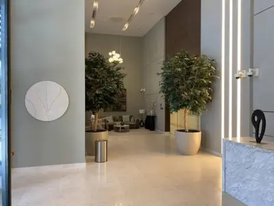 a hallway with three potted trees in a building at Vogue Creek Harbour Edge Tower Waterfront Living Close to Downtown, Burj Khalifa and Dubai Mall, One Bedroom Apartment with Balcony and Canal View, Access to all Amenities in Dubai