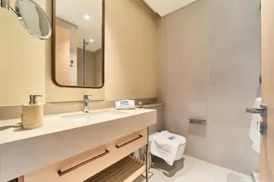 a bathroom with a sink and a mirror and a toilet at Iconic 2BR Vida Dubai Mall with Direct Mall Access in Dubai