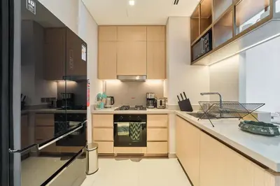 a kitchen with wooden cabinets and a stove top oven at Iconic 2BR Vida Dubai Mall with Direct Mall Access in Dubai
