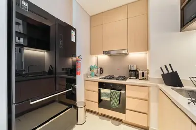 a kitchen with a black refrigerator and a sink at Iconic 2BR Vida Dubai Mall with Direct Mall Access in Dubai