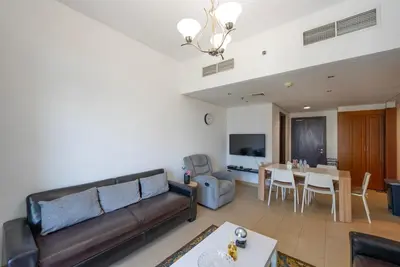 a living room with a couch and a table at Modern 1 BHK Retreat in Lakeside JLT in Dubai