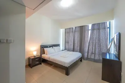 a bedroom with a bed and a large window at Modern 1 BHK Retreat in Lakeside JLT in Dubai