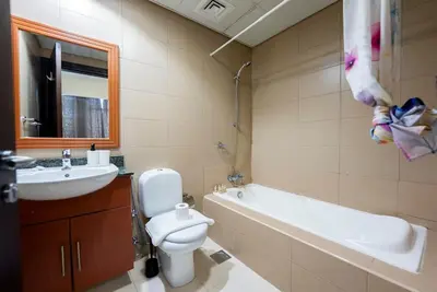 a bathroom with a sink and a toilet and a bath tub at Modern 1 BHK Retreat in Lakeside JLT in Dubai