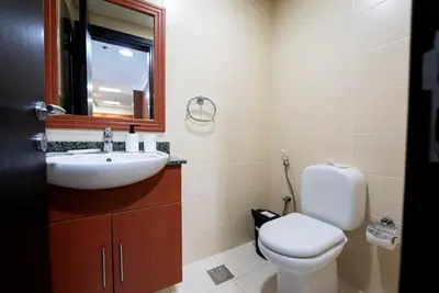 a bathroom with a toilet and a sink and a mirror at Modern 1 BHK Retreat in Lakeside JLT in Dubai