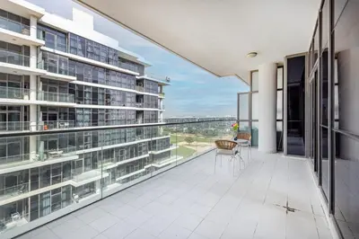 an apartment balcony with a view of the city at Golf Promenade 2-B, Damac Hills - 2BR Apartment - Allsopp & Allsopp in Dubai